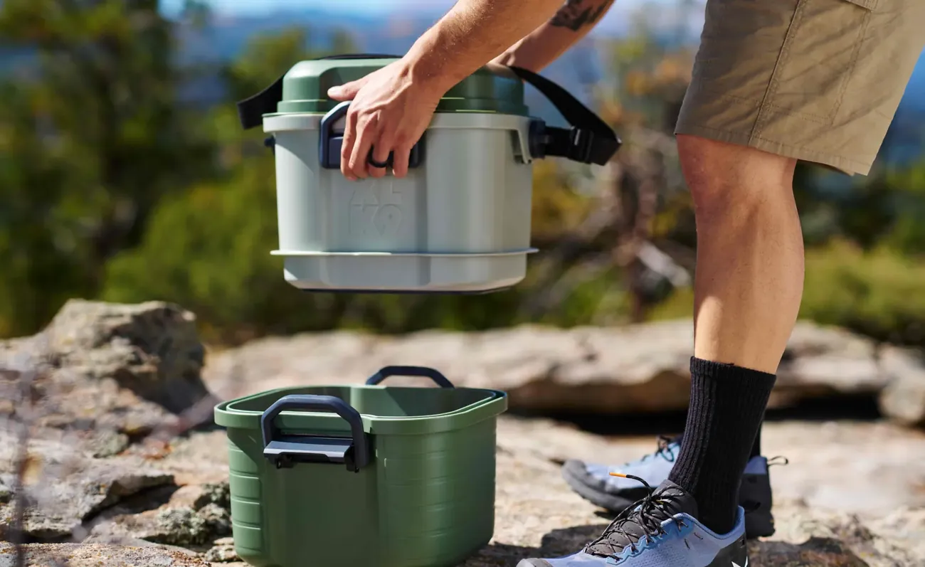 Carrying an XLK9 Basecamp unit on a rocky summit trail.